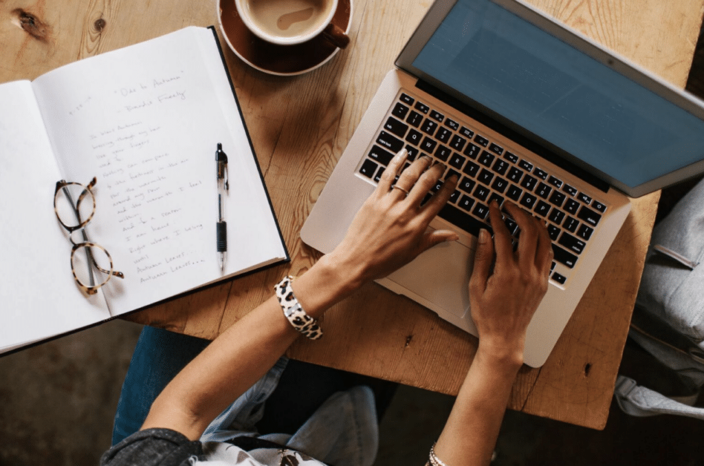 A personal business writer typing on a laptop.